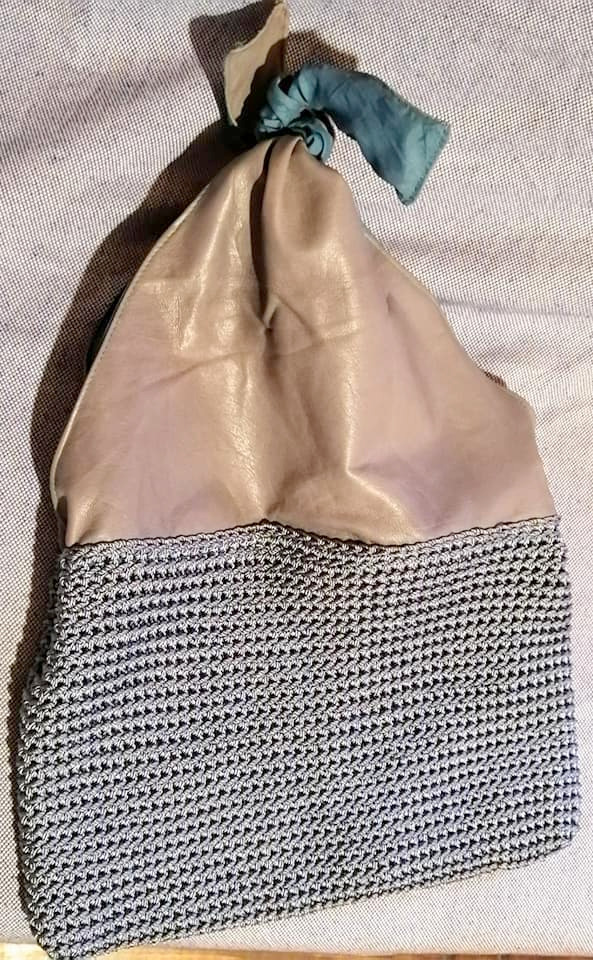 Cartera en napa gris combinado con cordón de seda al tono y forrada en color contrastante